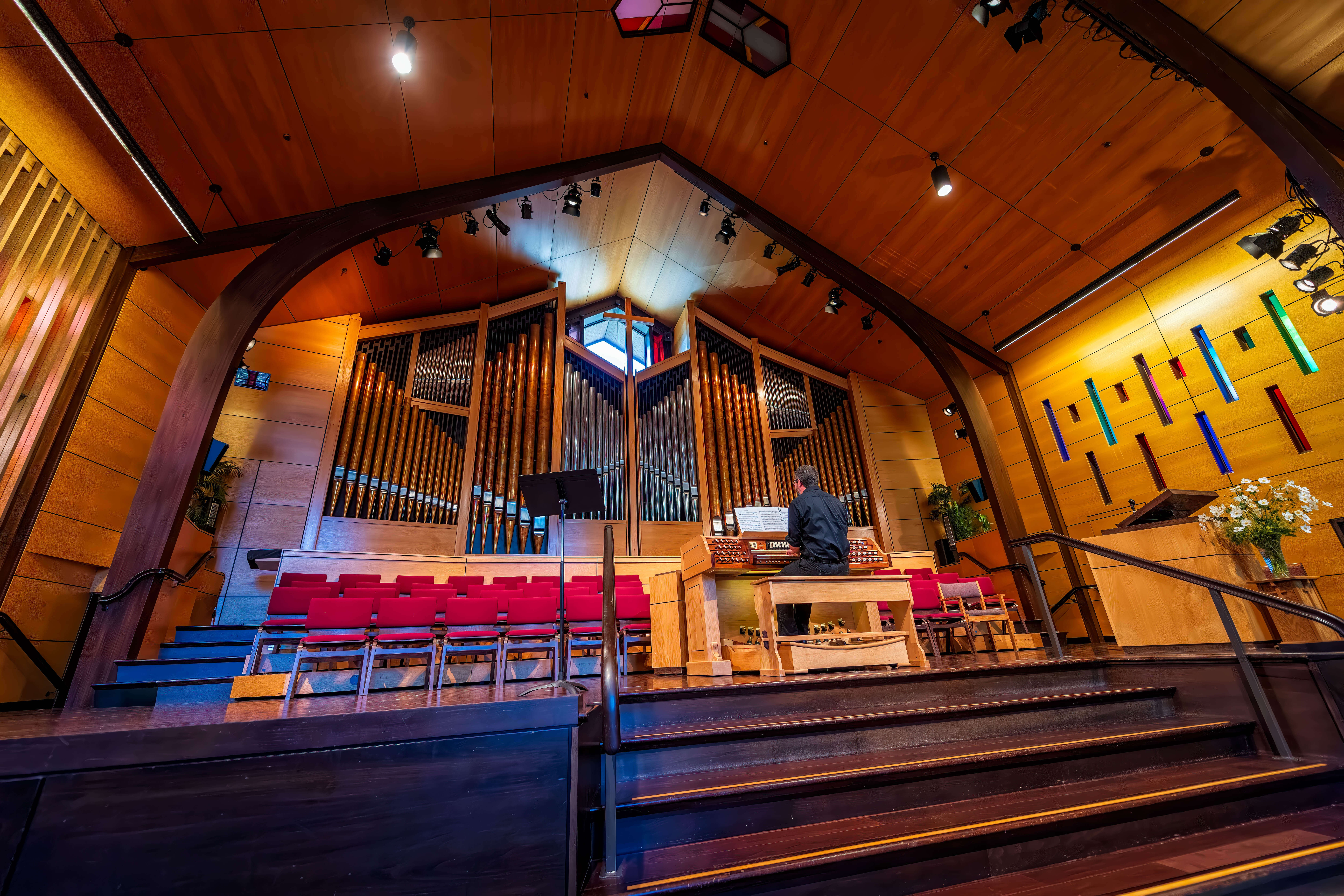 A large pipe organ with a man at the console..